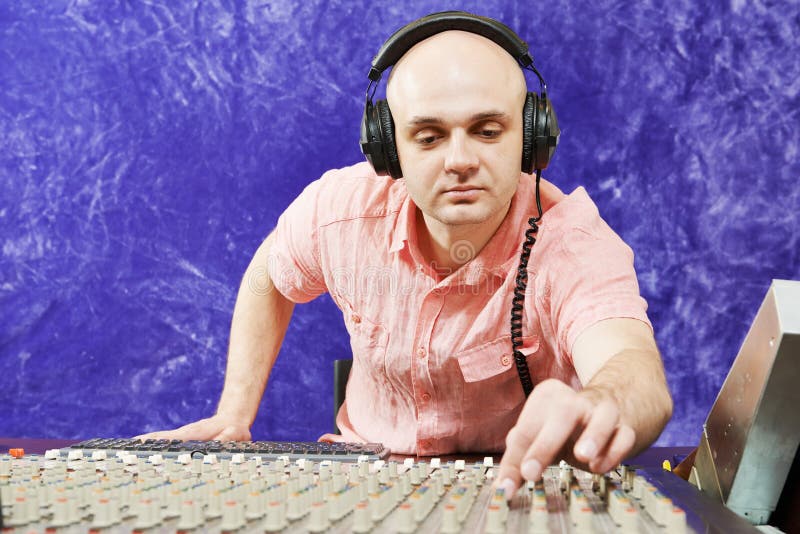 Den solida teknikern arbetar med den yrkesmässiga musikaliska blandaren arkivbild Den solida teknikern arbetar med den yrkesmässiga musikaliska blandaren arkivbild