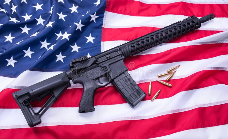 Den specialbyggda karbinen AR-15 och kulor på amerikanska flaggan ytbehandlar, bakgrund härlig för studiokvinna för par dans skju