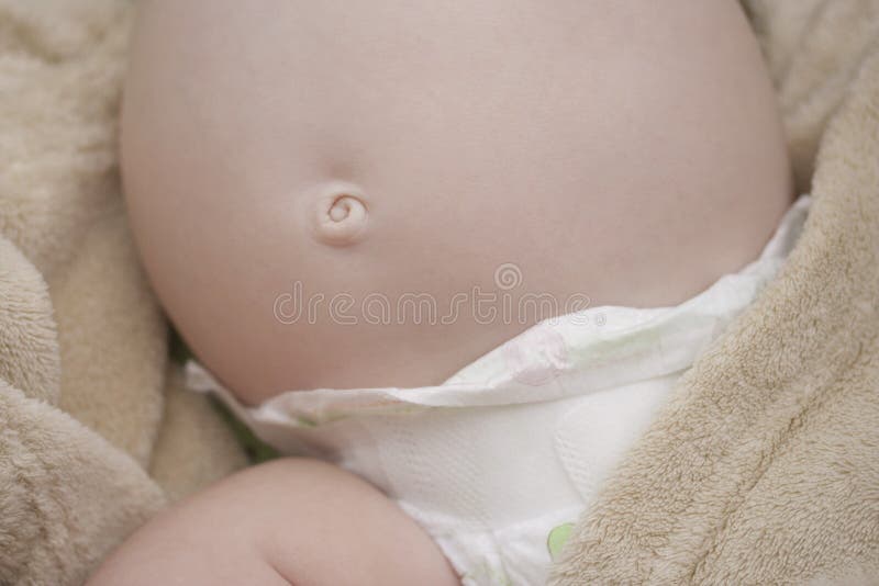 Sweet belly over a nappy of a child and a little belly button curl on a tender skin. Sweet belly over a nappy of a child and a little belly button curl on a tender skin.