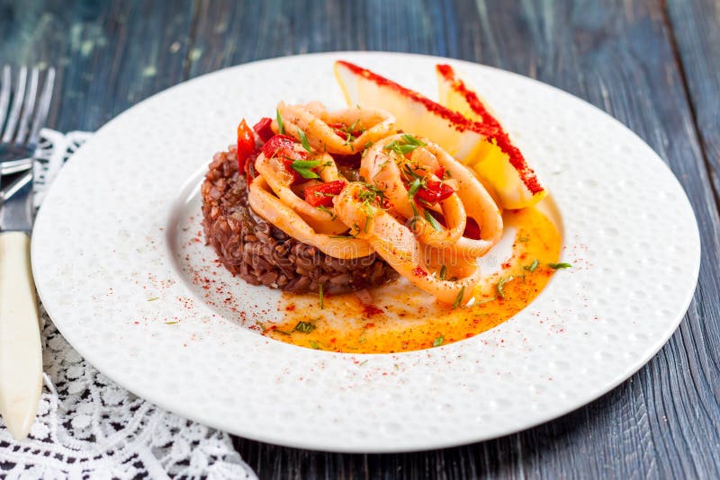 Den stekte tioarmade bläckfisken ringer med röda ris royaltyfri fotografi Den stekte tioarmade bläckfisken ringer med röda ris royaltyfri fotografi
