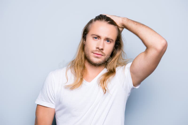 Den stiliga brutala mannen med borstet kammar hans långa blonda hår arkivbild Den stiliga brutala mannen med borstet kammar hans långa blonda hår arkivbild