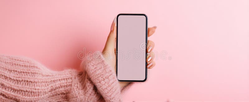 Den stilta smartphone som hålls av en moderiktig hand mot en rosa bakgrundAI genererade bild arkivfoton