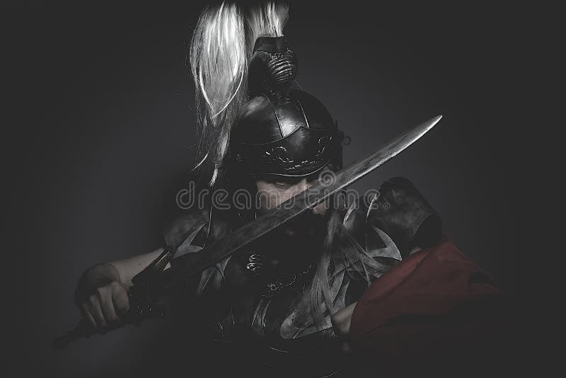 Strengh warrior helmet, armor and red cape on a battlefield, conflict and struggle in the Roman Empire. Strengh warrior helmet, armor and red cape on a battlefield, conflict and struggle in the Roman Empire