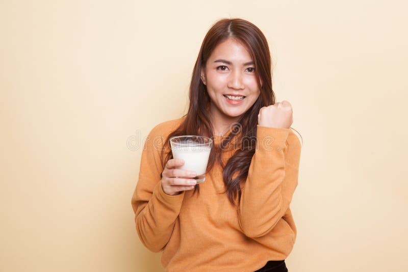 Den sunda asiatiska kvinnan som dricker ett exponeringsglas av, mjölkar