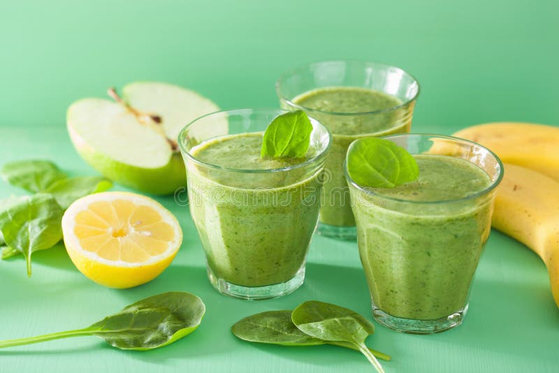 Den sunda gröna smoothien med spenat lämnar äpplecitronbananen arkivfoto Den sunda gröna smoothien med spenat lämnar äpplecitronbananen arkivfoto