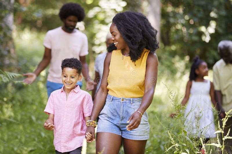 Den svarta modern och sonen går med familjen och vänner i trän fotografering för bildbyråer Den svarta modern och sonen går med familjen och vänner i trän fotografering för bildbyråer
