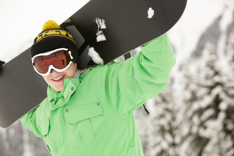 Den tonårs- pojken med snowboarden skidar på ferie fotografering för bildbyråer Den tonårs- pojken med snowboarden skidar på ferie fotografering för bildbyråer