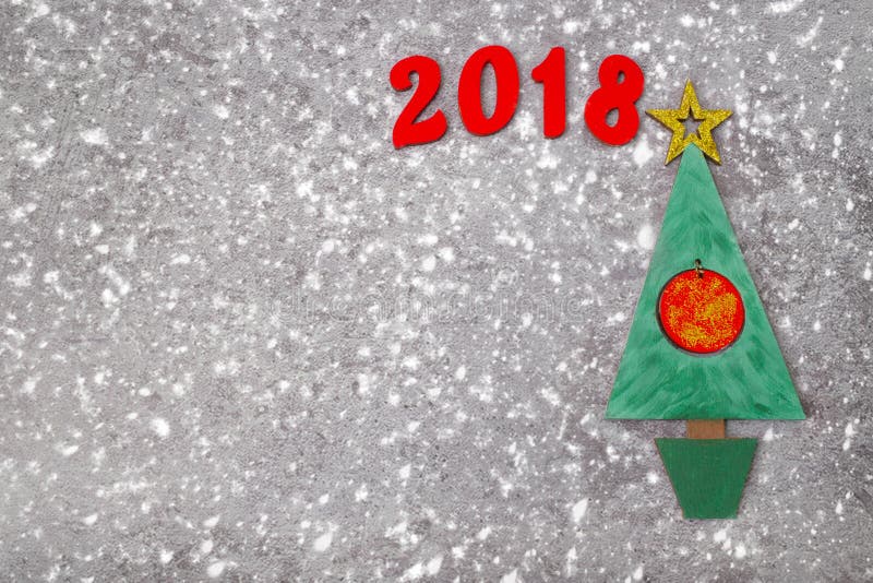 Wooden Green Christmas tree and sign 2018 from wooden redletters, gray concrete background. Happy new year 2018 backdrop. Greeting card. Wooden Green Christmas tree and sign 2018 from wooden redletters, gray concrete background. Happy new year 2018 backdrop. Greeting card.