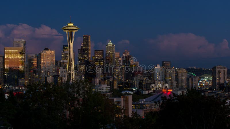 Den Tume schackningsperioden av moln och natten tänder över cityscape av Seattle Washington från solnedgång för att slösa timme-