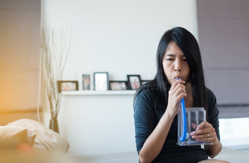 Den tålmodiga användande incentivespirometeren eller tre bollar för stimulerar lungan arkivfoto Den tålmodiga användande incentivespirometeren eller tre bollar för stimulerar lungan arkivfoto