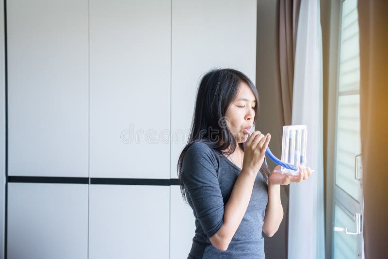 Den tålmodiga användande incentivespirometeren eller tre bollar för stimulerar lungan royaltyfri foto Den tålmodiga användande incentivespirometeren eller tre bollar för stimulerar lungan royaltyfri foto