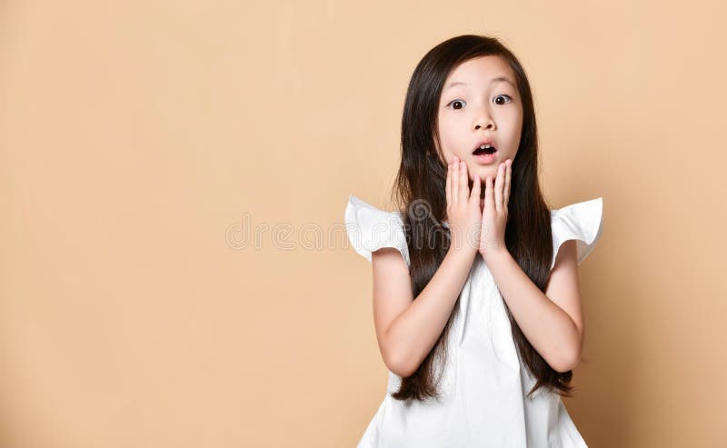 Den unga asiatiska flickan förvånade upphetsat lyckligt skrika Gladlynt unge med roligt glat framsidauttryck arkivfoto Den unga asiatiska flickan förvånade upphetsat lyckligt skrika Gladlynt unge med roligt glat framsidauttryck arkivfoto