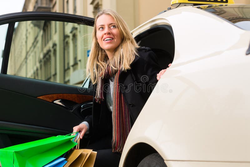 Den unga kvinnan får ut ur taxar fotografering för bildbyråer Den unga kvinnan får ut ur taxar fotografering för bildbyråer