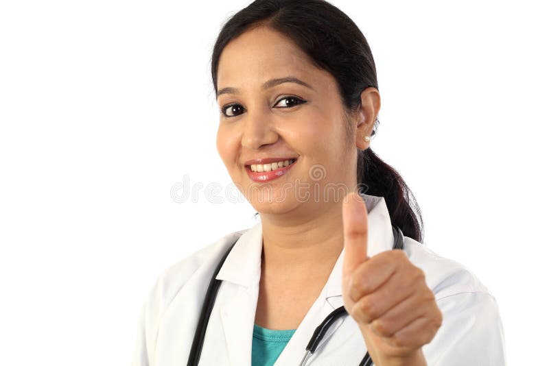 Den unga kvinnliga doktorn med tummar gör en gest upp arkivbilder Den unga kvinnliga doktorn med tummar gör en gest upp arkivbilder
