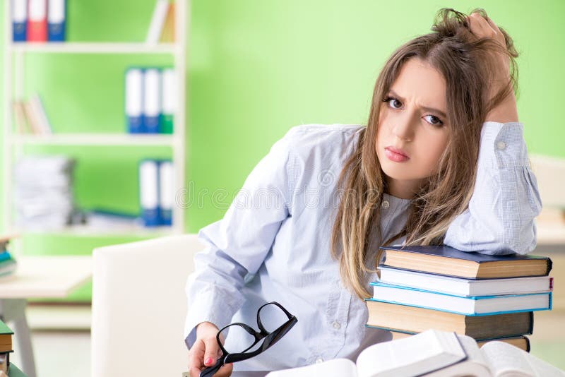 Den unga kvinnliga studenten som förbereder sig för examina med många böcker fotografering för bildbyråer Den unga kvinnliga studenten som förbereder sig för examina med många böcker fotografering för bildbyråer