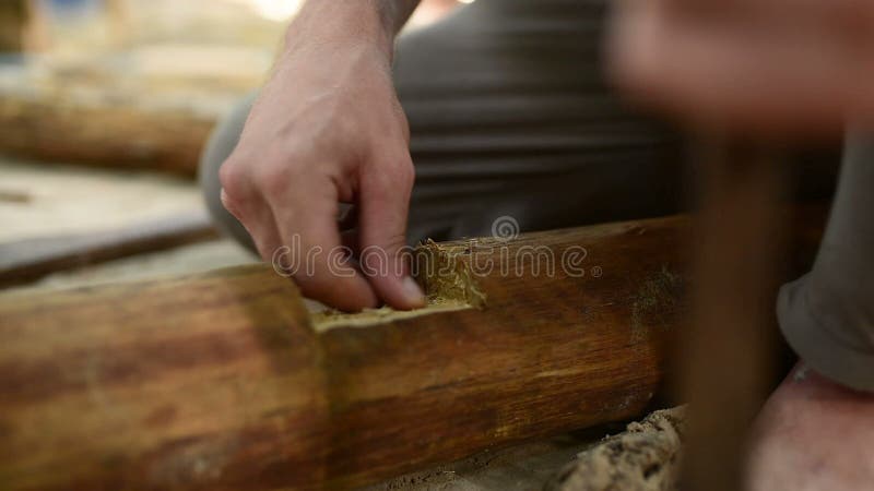 Den unga mannen förbereder trä för att bygga hem- konstruktion vid den traditionella vägen