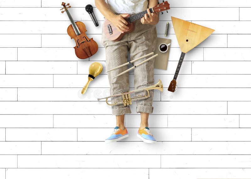 Den unga mannen sitter och spelar gitarren arkivfoto Den unga mannen sitter och spelar gitarren arkivfoto