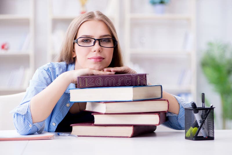 Den unga tonårs- kvinnliga studenten som hemma förbereder sig för examina arkivbild Den unga tonårs- kvinnliga studenten som hemma förbereder sig för examina arkivbild