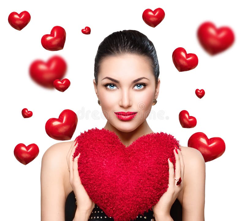 Den ursnygga unga brunettkvinnan med hjärta formade den röda kudden Valentine dag royaltyfri bild Den ursnygga unga brunettkvinnan med hjärta formade den röda kudden Valentine dag royaltyfri bild