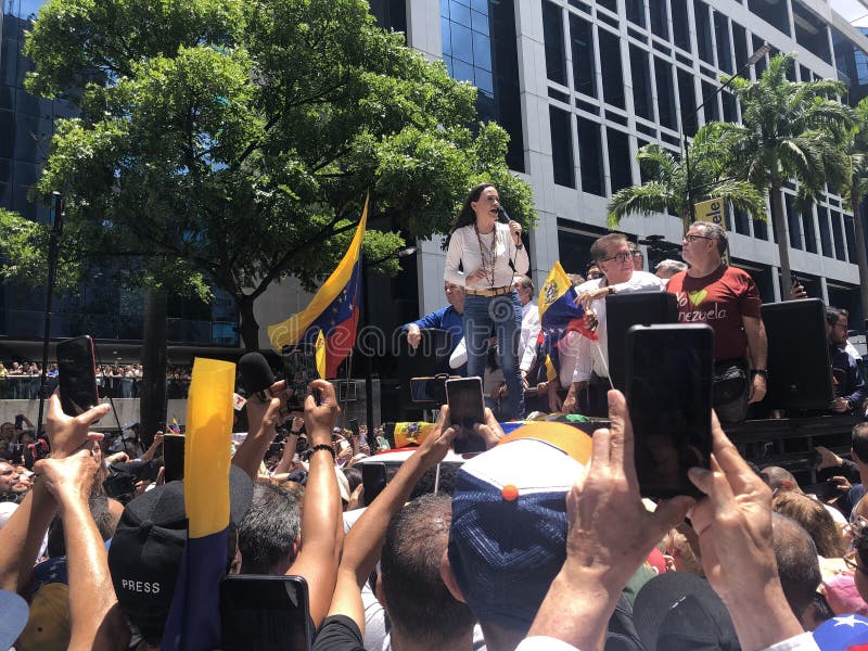 Den venezuelanske oppositionsledaren Maria corina machado talar till anhängare medan han håller röstsedlar under ett möte royaltyfri foto
