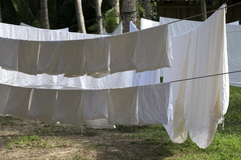 Den vita torkduken exponeras till solen på klädstrecket royaltyfri bild Den vita torkduken exponeras till solen på klädstrecket royaltyfri bild