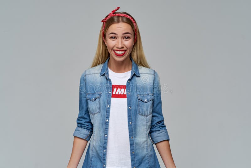 Den vänliga lyckliga unga långhåriga blondinen ler brett och skrattar glatt royaltyfri bild Den vänliga lyckliga unga långhåriga blondinen ler brett och skrattar glatt royaltyfri bild