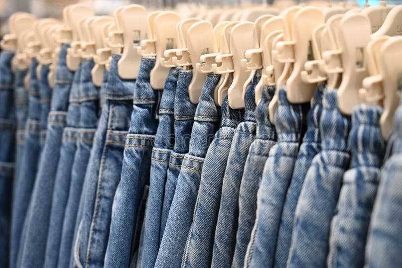Denim Jeans Store Detail. Row of Blue Jeans Hung on Plastic Hangers in ...