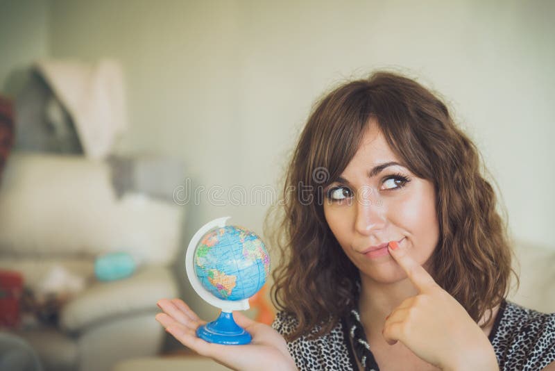 Denkende Frau, die in der Hand kleine Kugel hält lizenzfreies stockbild Denkende Frau, die in der Hand kleine Kugel hält lizenzfreies stockbild