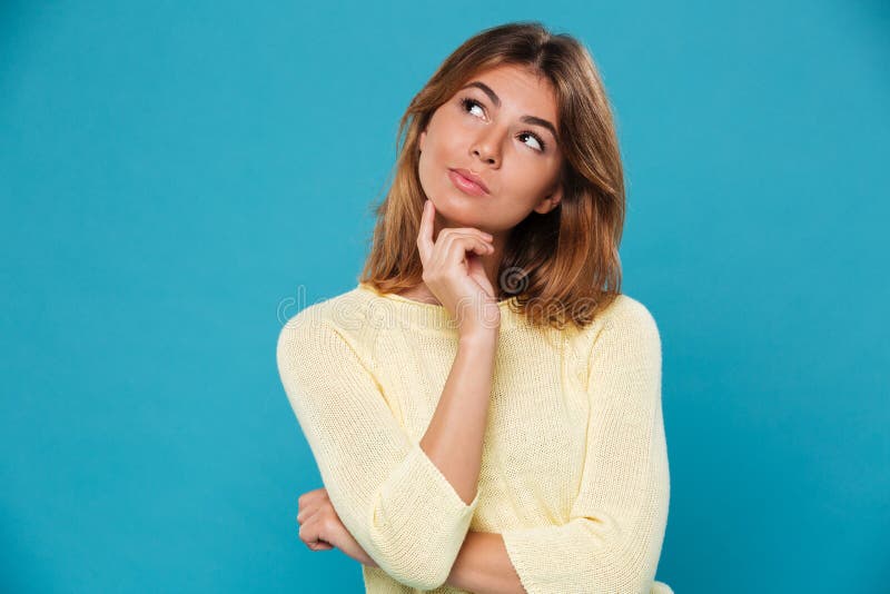 Denkende hübsche Frau über blauem Hintergrund lizenzfreie stockfotos