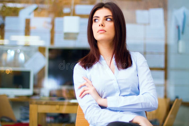 Portrait of a thinking young woman looking away in office. Portrait of a thinking young woman looking away in office