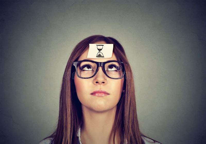 Denkende vrouw met de sticker van de zandklok op voorhoofd Het Concept van het tijdbeheer stock afbeeldingen Denkende vrouw met de sticker van de zandklok op voorhoofd Het Concept van het tijdbeheer stock afbeeldingen