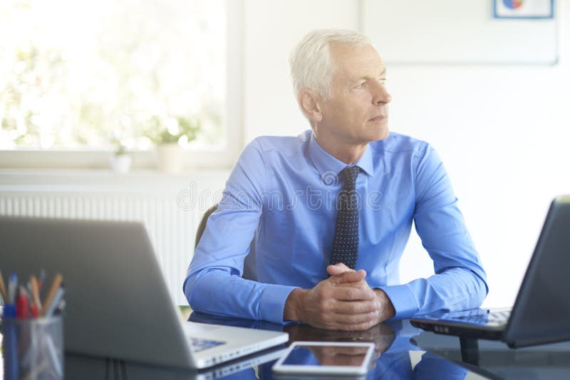 Denkende zakenman die in het bureau werken stock afbeeldingen Denkende zakenman die in het bureau werken stock afbeeldingen