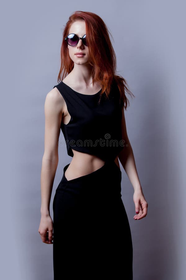 Denomine a menina do redehad no vestido e em óculos de sol pretos imagens de stock Denomine a menina do redehad no vestido e em óculos de sol pretos imagens de stock