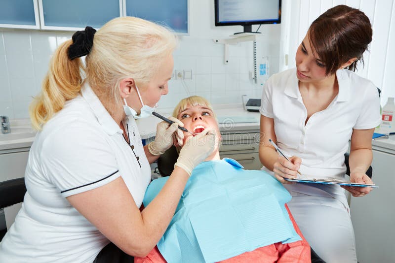 Dental Assistant during Apprenticeship Watching Dentist Stock Image