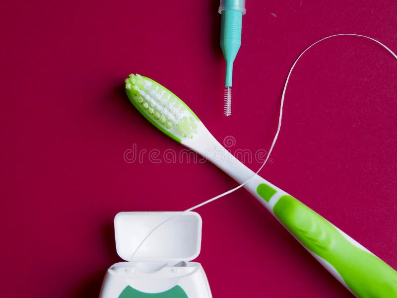 Dental Floss, Interdental Brush and Toothbrush on Red Background Stock