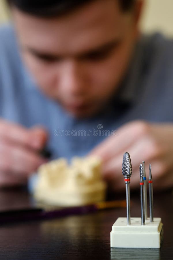 Dental Technician Modelling Tooth Crowns with Hot Wax. Workplace of a