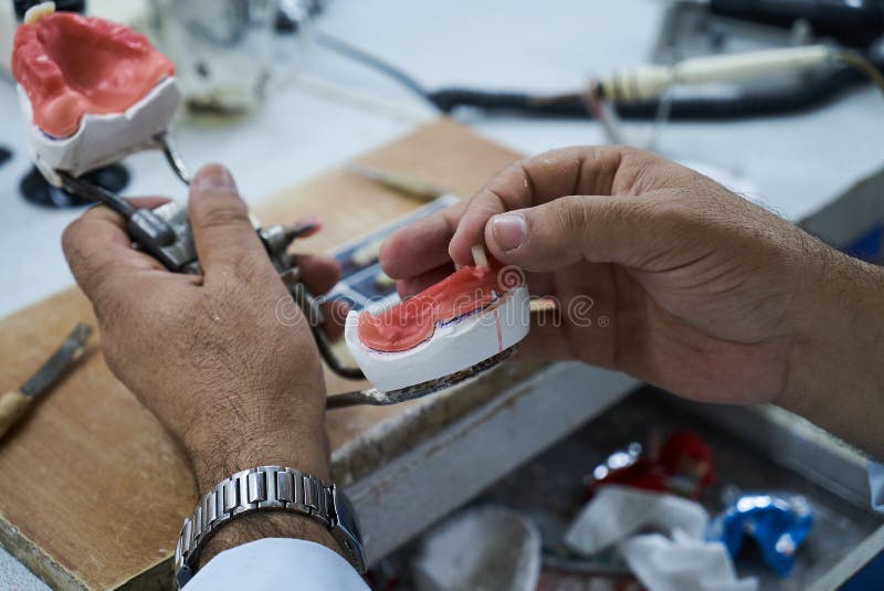 Dental Technician Using a Knife with Ceramic Dental Implants Stock
