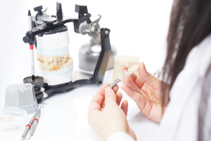 Dental Technician Working with Articulator in Dental Laboratory Stock