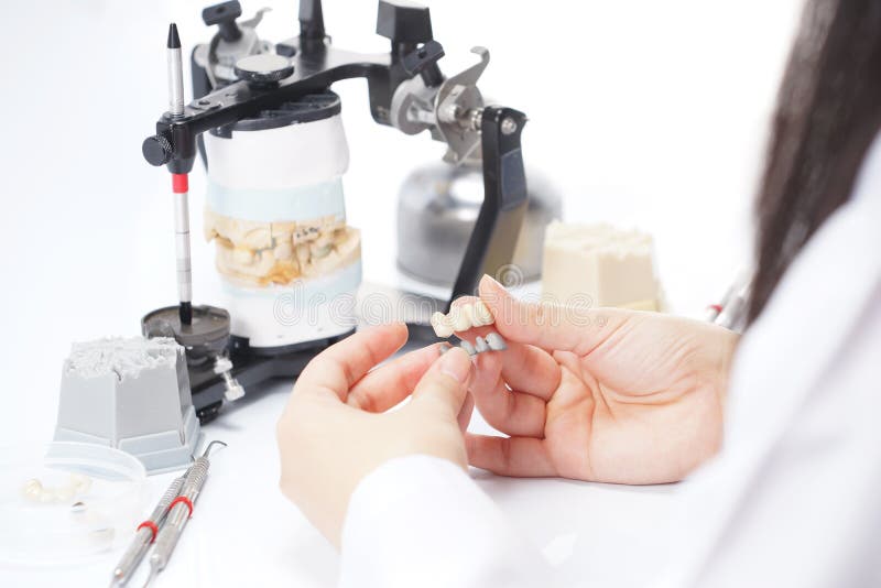 Dental Technician Working with Articulator in Dental Laboratory Stock