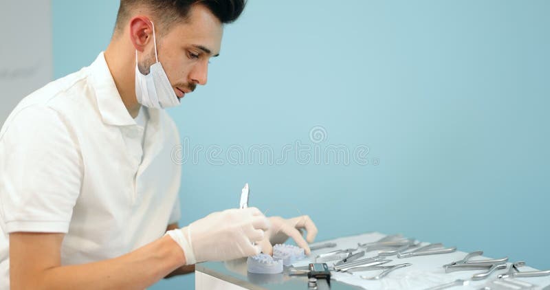 Dental technician working with a model of teeth and dental braces stock video
