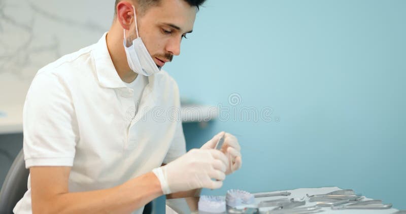 Dental technician working with a model of teeth and dental braces stock video