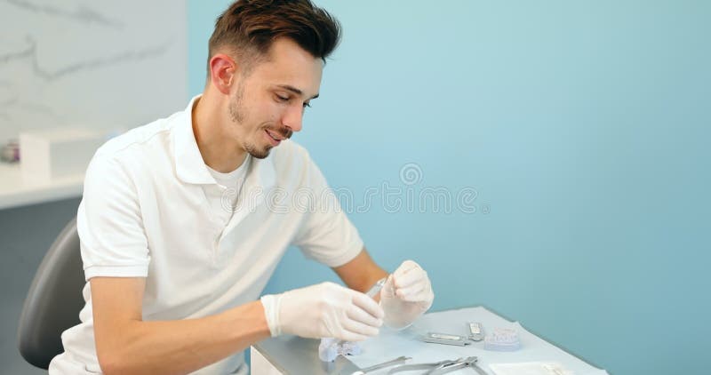 Dental technician working with a model of teeth and dental braces stock video footage