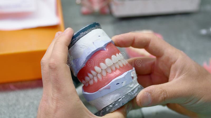 Dental technician works in his workshop and makes teeth for dentistry stock video