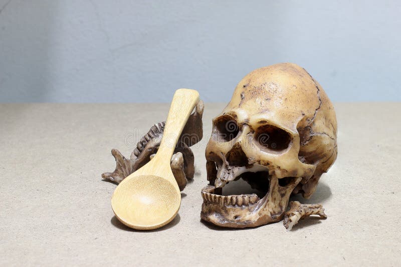 Dente con la carie, denti tagliati, cranio umano con il cucchiaio di legno su fondo di legno - natura morta immagini stock Dente con la carie, denti tagliati, cranio umano con il cucchiaio di legno su fondo di legno - natura morta immagini stock