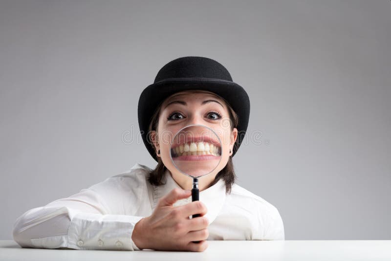 Dentes atrás de uma lente de aumento e de uma cara engraçada fotografia de stock Dentes atrás de uma lente de aumento e de uma cara engraçada fotografia de stock