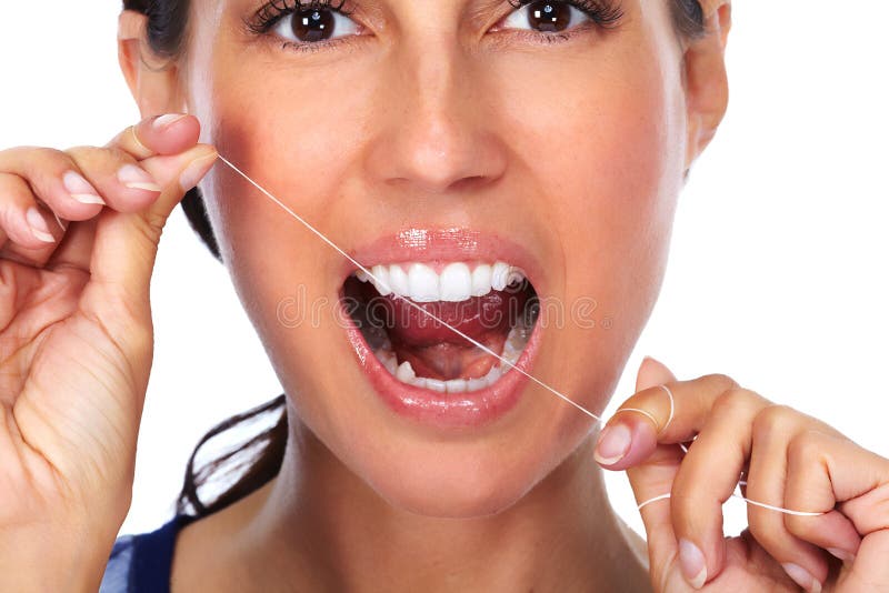 Denti della donna con filo per i denti fotografia stock Denti della donna con filo per i denti fotografia stock
