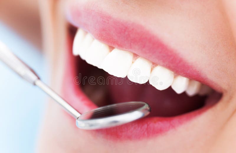 Denti della donna e uno specchio del dentista