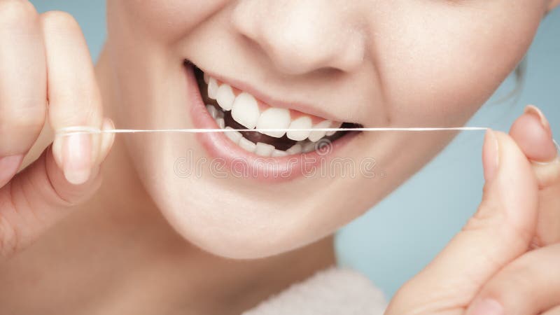 Denti di pulizia della ragazza con filo per i denti. Sanità fotografia stock libera da diritti Denti di pulizia della ragazza con filo per i denti. Sanità fotografia stock libera da diritti