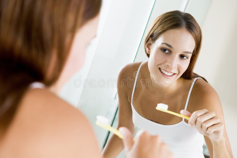 Denti di spazzolatura della donna fotografie stock libere da diritti Denti di spazzolatura della donna fotografie stock libere da diritti