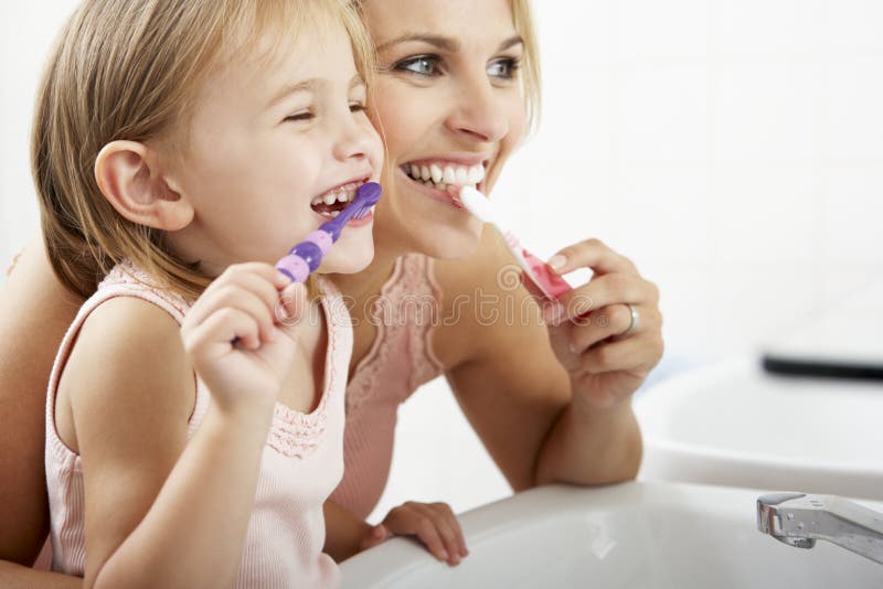 Denti di spazzolatura della figlia e della madre insieme